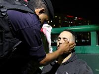 Jordanian riot police attend to a protester who passed out during a demonstration outside the prime minister's office in the capital Amman late on June 3, 2018. 
Khalil MAZRAAWI / AFP