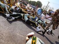 This picture taken on September 22, 2018 in the southwestern Iranian city of Ahvaz shows a soldier running past injured comrades lying on the ground at the scene of an attack on a military parade. (MORTEZA JABERIAN / ISNA / AFP)