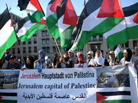 People wave Palestinian flags as they protest in front of the US embassy in Berlin on May 14, 2018. Britta Pedersen / dpa / AFP