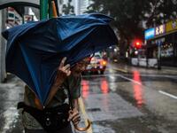 An elderly man waits for a taxi while holding his umbrella as super Typhoon Mangkhut edges closer to Hong Kong on September 16, 2018. 
Anthony WALLACE / AFP