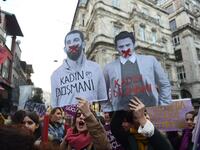 A women's rights activist holds a picture of Turkish football player Arda Turan (L) with the lettering 'Enemy of woman' as activists march through Taksim Square to protest against gender violence in Istanbul, on November 25, 2018, on the International Day for the Elimination of Violence against Women. 
BULENT KILIC / AFP