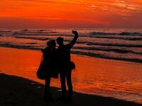 Palestinian people take a picture on the beach at sunset west of in Gaza city on December 31, 2018. 
MAHMUD HAMS / AFP