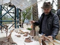 Lebanese Artist Charles Nassar inpsects his sculptures made out of artillery shrapnels in the village of Remhala, south of Beirut, on March 7, 2019.
JOSEPH EID / AFP