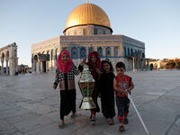 Palestinian girls pose for a picture with a Ramadan lantern in front of the Dome of the Rock at the Al-Aqsa Mosque compound in the Old City of Jerusalem. 
Ahmad Gharabli/AFP
