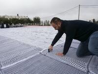 Palestinian students of the Southern Education Direction prepare to apply for the Guinness book of World Records' largest Keffiyeh. (HAZEM BADER / AFP)