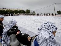 Palestinian students of the Southern Education Direction surround the largest Keffiyeh. (HAZEM BADER / AFP)