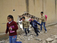 Children run through a huge hole in a wall at the school in Kobani. The Kurdish People’s Protection Units (YPG) reopened the first primary school in 2015, following the defeat of Daesh.