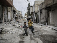 Children swing on an electrical wire hanging off a damaged building in Kobani. After the liberalization from Daesh in 2015, many people have returned to the city. Yet, reconstruction has been made difficult by the closure of border crossings with Turkey that prevented the importation of goods such as cement, iron, medicines, food and technology.