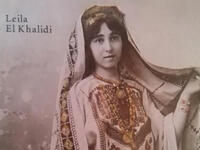 A Palestinian girl wears a traditional embroidered gown and headdress on the book cover of “Art Of Palestinian Embroidery“ by Laila El-Khalidi. (Laila El-Khalid, Saqi Books) 