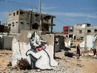 Banksy’s cute kitty plays with a ball of tangled steel (Gazan “yarn”), a jarring contrast to the destruction around him. Says the artist on his website, "A local man came up and said 'what does this mean?' I explained I wanted to highlight the Gaza destruction by posting photos, but on the internet people only look at pictures of kittens."