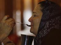 A coptic priest gives a mourning Egyptian woman her communion during Sunday mass on at the Al-Qiddissine church.
