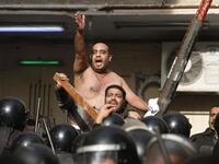 Egyptian Christians face riot police during confrontations outside the Al-Qiddissine church.