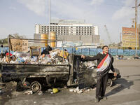 A burnt car filled with garbage sports a sign reading, "National Party Headquarters".