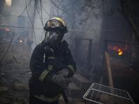 An Israeli firefighter stands at the site of a burning house in the village of Ein Hod, as the massive fire ripping through northern Israel was still incinerating swathes of land, with little sign that Israeli and foreign firefighters were winning the battle to contain it.