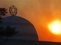 The sun rises amidst smoke of ongoing fire in Tirat Ha Carmel near the northern city of Haifa.