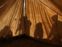 Children of a displaced Palestinian family are reflected on their ten as they play outside on in the Ezbet Abed Rabbo area, that was heavily destroyed during Israel's 22-day offensive on the Gaza Strip two years ago.