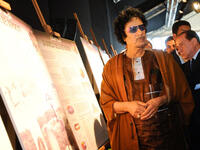 Like a "Rock Star" Gaddafi attends the photo exhibition wearing his shades!