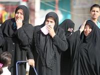 Iraqi Shiite Muslim women grieve as they watch the funeral procession of people killed in a bomb blast that targeted a convoy of pilgrims in the Ghazaliyah district of Baghdad as Shiite Muslims prepare to mark the religious event of Ashura on December 17.