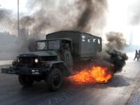 A Lebanese army truck drives through burning tires.