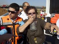 An Israeli woman is evacuated from a burning train coach near Kibbutz Shfaim, close to the Israeli city of Netanya.