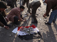 Anti-government protestors place broken paving stones on an Egyptian flag to throw at supporters of President Mubarak.