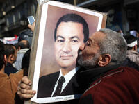 A man kisses a photograph of President Hosni Mubarak during a pro-government demonstration.