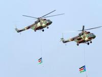 Southern Sudanese military helicopters fly an overpass carrying two Southern Sudan flags during a ceremony in the capital Juba on July 9, 2011 to celebrate South Sudan's independence from Sudan.