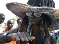 A traditional Southern Sudanese dancer blows into a horn during the ceremony in the capital Juba.