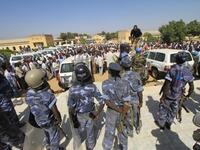 Sudanese policemen stand guard as university students gather during a protest against the visit of Darfur mediators from Qatar and the UN outside the University of Zalingei in western Darfur.