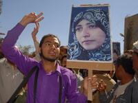 YEMEN: Yemeni protesters, holding up pictures of detained political activist Tawakel Karman protest, January 24, 2011.