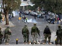 LEBANON: Lebanese soldiers look on as supporters of former Lebanese prime minister Saad Hariri Future Movement flee from tear gas, January 25, 2011.
