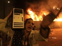 An Egyptian man loots a computer from the burning headquarters of the of the ruling National Democratic party.