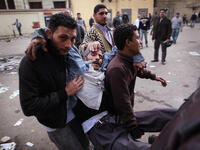 Protesters carry an injured man during clashes with riot police near Tahrir Square.