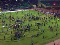 Fans rushing off the football pitch. 'Ultra' trouble-maker, fanatic football fans who had also been involved in the revolution - happy to make sport a politically-charged arena. These Ultras may have been finishing off business from Tahrir, specifically at the 'camel' battle. Al Masry fans held provocative banners aimed at the rival team Al Ahly.