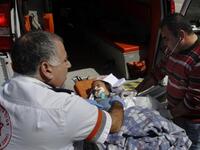Israeli and Palestinian paramedics treat a wounded Palestinian boy being transfered for medical treatment to an Israeli hospital after he was injured in an Israeli army attack on the Palestinian Gaza Strip.