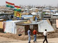 Syrian-Kurdish refugees walk along a dirt road at the Domiz refugee camp, 20 km southeast of the northern Iraqi city of Dohuk (AFP)