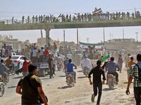 Syrians chant slogans and wave flags of the opposition as they protest against a promised government assault on Idlib province. (Zein Al RIFAI / AFP)