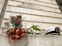 An impromptu memorial of flowers and a U.S. Navy officers hat stands outside of the Russell Senate Office Building in honor of Sen. John McCain (R-AZ) August 27, 2018 in Washington, DC. (AFP)