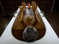 A man bathes in a tub filled with Naftalan crude oil during a treatment session at Sehirli Naftalan Health Center, some 300 kilometres (186 miles) from capital Baku, on March 21, 2019. Immersed up to her neck in crude oil, a Russian woman suffering from joint disease smiles in delight, confident that the treatment at a spa in northwestern Azerbaijan will cure her painful condition.  Mladen ANTONOV / AFP