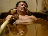 A man bathes in a tub filled with Naftalan crude oil during a treatment session at Qarabag luxury resort in Naftalan, some 300 kilometres (186 miles) from capital Baku, on March 21, 2019. Immersed up to her neck in crude oil, a Russian woman suffering from joint disease smiles in delight, confident that the treatment at a spa in northwestern Azerbaijan will cure her painful condition.  Mladen ANTONOV / AFP