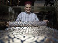 Abdelkader Ouazzani, the last of Morocco's brocade master weavers, displays tapestry at his workshop in the old city of Fez on April 10, 2019. His skilfull hands intricately create shimmering silk fabrics, enhanced with gold or silver thread, for bridal jewellery, designer creations or high-end furnishings. FADEL SENNA / AFP
