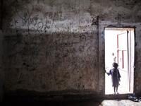 A young South Sudanese Refugee stands on the doorstep of a building located in a transition camp for South Sudanese refugees who have just arrived in Aru. JOHN WESSELS / AFP