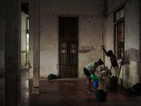 Inhabitants of the roca Agostinho Neto, an abandoned cocoa plantation of Sao Tome and Principe, prepare corn in the former hospital of the roca, on May 29, 2019.  Alexis HUGUET / AFP