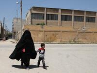 Hasna Dbeis, a 30-year-old former detainee in a Syrian-regime jail, holds her son Mohammad's hand, as they walk in the town of Maarat Nasrin, in the rebel-held part of the Syrian Idlib province  Aaref WATAD / AFP