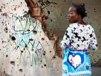 A woman, living in the bullet-riddled and graffiti-covered building that used to house Jonas Savimbi, leader of the rebel UNITA movement during the Angolan civil war, calls out, in Kuito, Bie Province in Angola. RODGER BOSCH / AFP