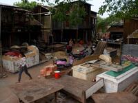 This picture  shows a woman walking past graves in Phnom Penh.  TANG CHHIN Sothy / AFP