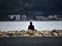 A migrant watches the sea at Samos' island capital city of Vathy.  LOUISA GOULIAMAKI / AFP