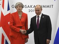 Russian President Vladimir Putin and British Prime Minister Theresa May shake hands during their meeting on the sidelines of the G20 summit in Osaka on June 28, 2019.  STR / POOL / AFP