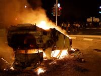 A burning and overturned police car blocks an entrance to the Israeli coastal city of Netanya , during a protest against the killing of Solomon Tekah, a young man of Ethiopian origin, who was killed by an off-duty police officer.  JACK GUEZ / AFP