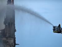 A Firefighter douse flames billowing from the roof at Notre-Dame Cathedral in Paris on April 15, 2019. A major fire broke out at the landmark Notre-Dame Cathedral in central Paris sending flames and huge clouds of grey smoke billowing into the sky. FRANCOIS GUILLOT / AFP